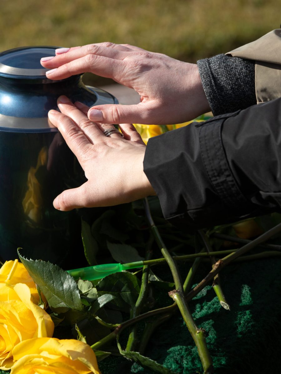 Hands,Touching,A,Burial,Urn,In,A,Bright,Outdoor,Funeral