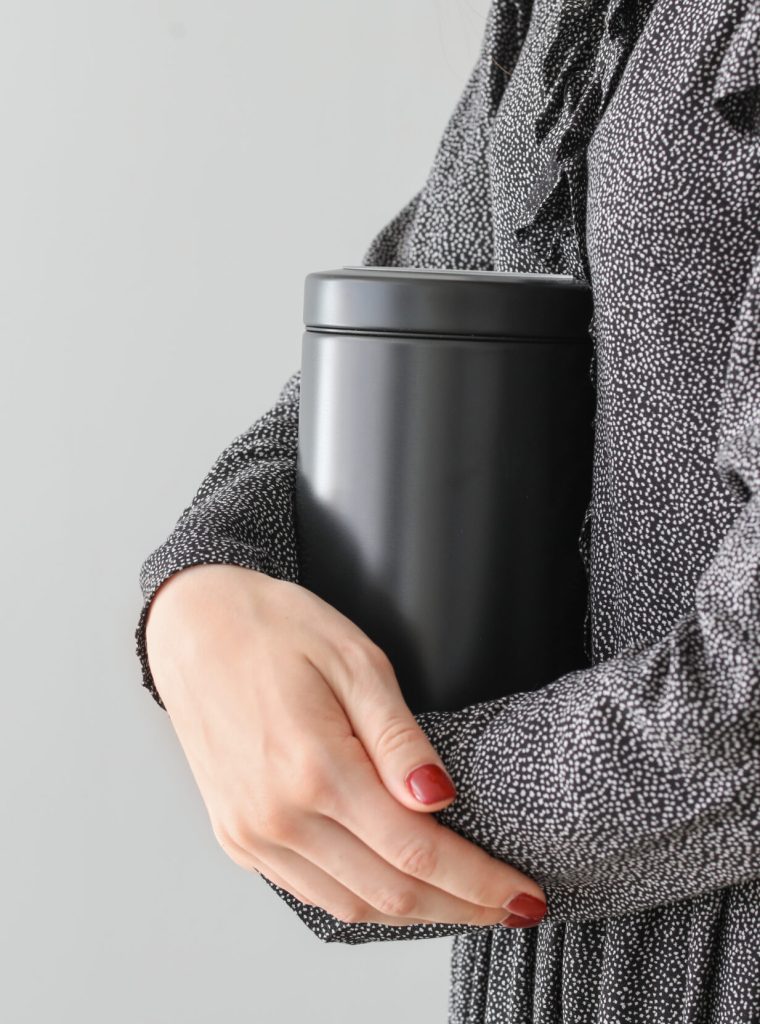 Woman,With,Mortuary,Urn,On,Light,Background